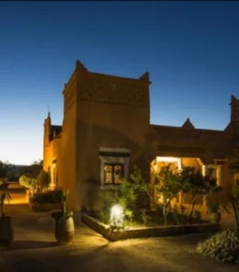 A kasbah-style guesthouse in Morocco with earthen walls and crenelated parapets, often seen during a 4 day desert tour from Marrakech to Fes.