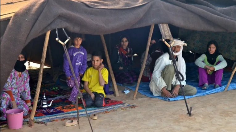A Berber nomadic family beside a traditional black tent in Morocco’s Sahara region, reflecting authentic cultural experiences highlighted by Morocco Trip Way.