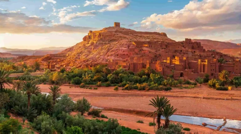 Ancient fortified ksar rises from arid landscape, showcasing earthen towers and traditional architecture on a 5 Days Tour from Marrakech to Merzouga.