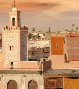 Aerial view of historic Jemaa el-Fnaa square with bustling market activity, surrounding rooftops, and crowds in central Marrakech below.